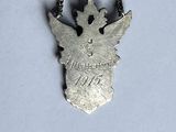 necklace with a silver angel on a chain on a white surface