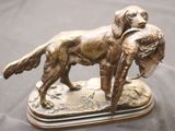 bronze statue of a dog with a duck in its mouth