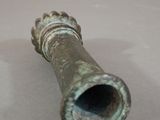 a small metal object on a table with a white background