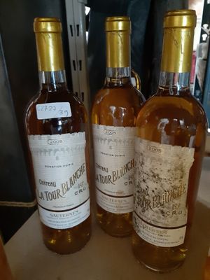 trois bouteilles de vin posées sur une table l'une à côté de l'autre