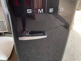 un petit réfrigérateur noir sur lequel est inscrit « sme »