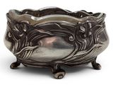 an antique silver bowl on a stand on a white surface