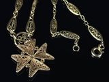 a close up of a gold necklace with a star on it