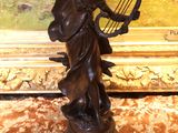 statue en bronze représentant une femme tenant une harpe posée sur une table en marbre
