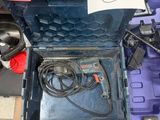 une boîte à outils bleue remplie d'outils, posée sur un sol à carreaux