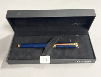 un stylo bleu dans une boîte noire posée sur une table blanche