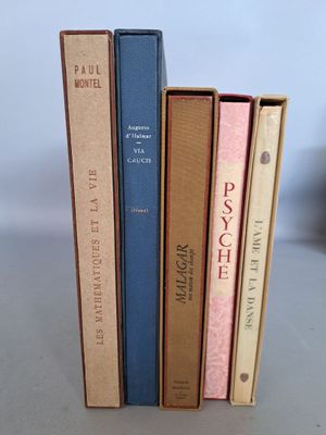 trois livres sont empilés sur une table