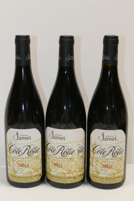 three bottles of wine are lined up on a table