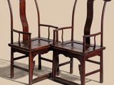 two wooden chairs with arms and backs are sitting side by side