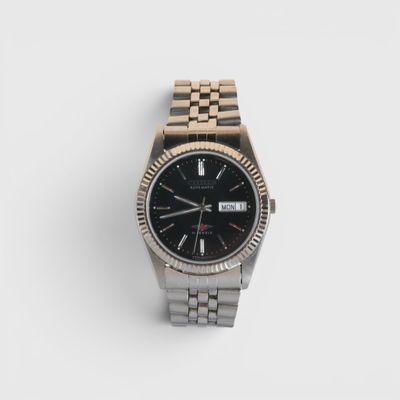 un gros plan d'une montre sur une surface blanche avec un fond blanc
