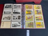 a lot of old postcards in a binder on a table