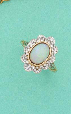 une bague ornée d'un oplite et d'un groupe de diamants