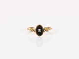 une bague en or sertie d'une pierre noire et d'un diamant blanc
