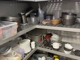 many dishes and pans on the shelves in the kitchen