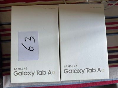 deux boîtes de Samsung Tab A et une Samsung Tab A posées sur un lit