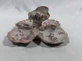 three small shells with flowers on them on a white surface