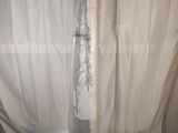 a picture of a tall silver vase on a white surface