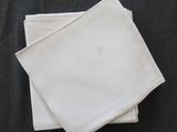 Deux serviettes blanches sont empilées l'une sur l'autre sur une table noire.