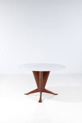 une table ronde avec un piètement en bois et un plateau blanc