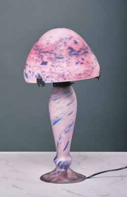 a pink and blue lamp on a marble table with a black cord