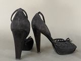 pair of black high heeled shoes with bows on the toes