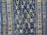 a blue rug with a design of flowers and leaves on it