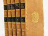 cinq livres alignés sur une surface blanche, sur fond blanc