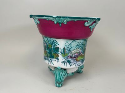 une jardinière rose et verte posée sur une table blanche