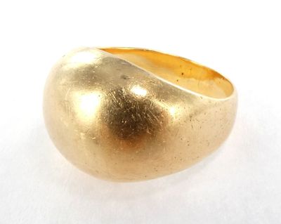 une image représentant une bague en or posée sur une surface blanche
