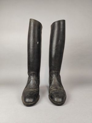 une paire de bottes d'équitation en cuir noir sur fond blanc