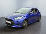 une Toyota Yaris bleue garée dans une pièce au sol noir