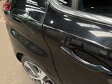 a black car parked in a parking lot next to a parking meter