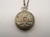 a silver pocket watch with a chain on a white surface