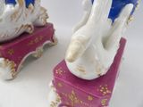 two figurines of swans sitting on a pink box