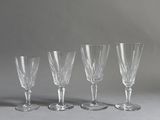 quatre verres à vin vides alignés sur une surface grise