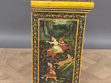 a small wooden box with a painting on it sitting on top of a wooden floor