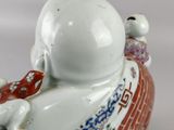 chinese porcelain figurine of a man with a fish on his back