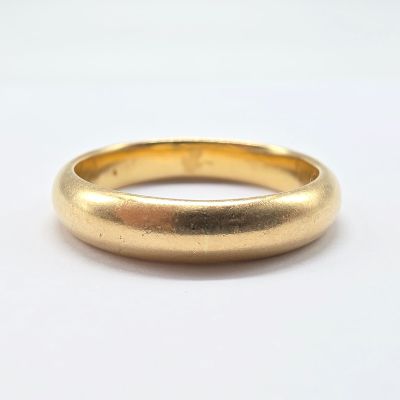 a close up of a gold ring on a white surface