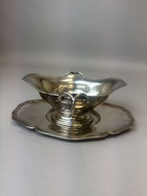 a silver plate with a silver saucer on it