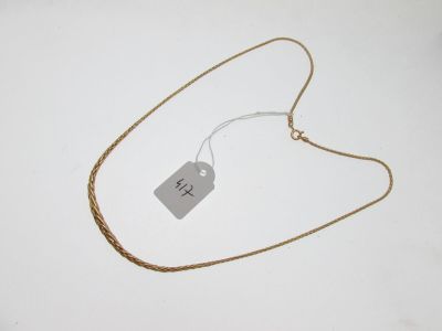 gros plan sur un collier en or portant une étiquette