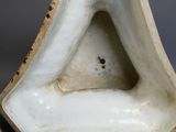 une image montrant un gros plan d'un vase blanc à la base incurvée
