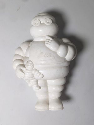 une petite figurine blanche représentant un homme tenant un bébé dans ses bras
