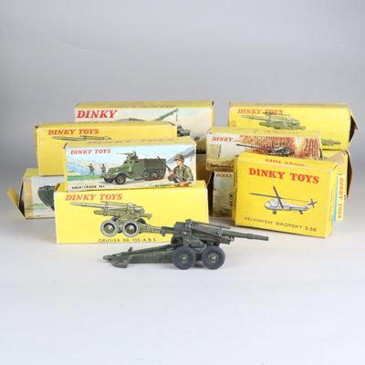 trois jouets Dinky Toys dans leur boîte, dont un véhicule militaire et un char d'assaut