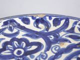 a blue and white plate with a flower design on it