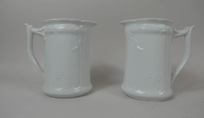 une paire de cruches en porcelaine blanche posées sur une surface blanche