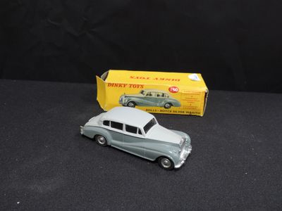 an old toy car sitting next to a boxed box on a black surface