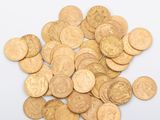 quelques pièces d'or sont éparpillées sur une surface blanche
