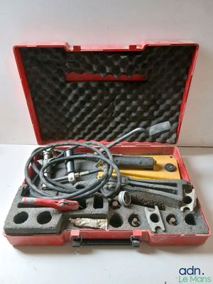 une mallette rouge contenant des outils, posée sur une table