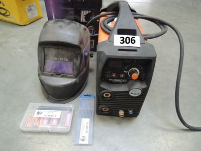 a welding machine and a helmet sitting on a table