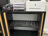 a black and white printer sitting on top of a black cabinet